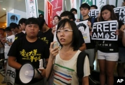 Singaporean protester Han Hui-hui (center) accompanied by Hong Kong students, speaks during a protest outside the Singapore Consulate in Hong Kong, June 30, 2015, to urge Singapore government to release teen blogger Amos Yee.