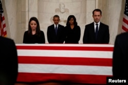 President Barack Obama, second from left, and first lady Michelle Obama, second from right, pay their respects at the casket of Supreme Court Justice Antonin Scalia in the Supreme Court's Great Hall in Washington, Feb. 19, 2016.