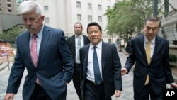 FILE - Ng Lap Seng, center, leaves federal court in Manhattan, July 27, 2017.