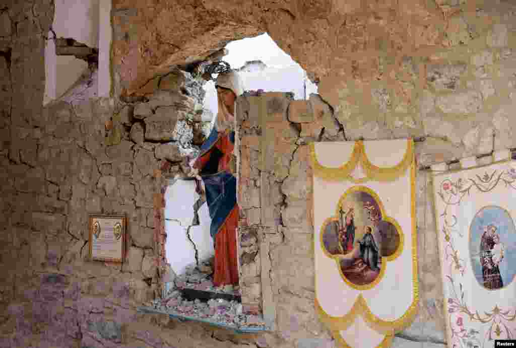 A Virgin Mary statue is seen in a damaged cemetery following an earthquake at Sant&#39; Angelo near Amatrice, central Italy.