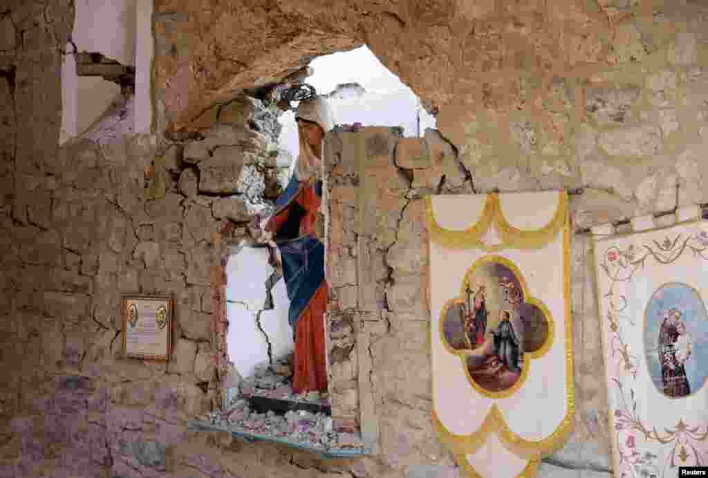A Virgin Mary statue is seen in a damaged cemetery following an earthquake at Sant' Angelo near Amatrice, central Italy.
