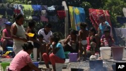 ARCHIVO-Indígenas waraos de Venezuela preparan comidas en un área al aire libre de un refugio en Pacaraima, el principal punto de entrada para los venezolanos, en el estado brasileño del norte de Roraima. (AP Photo / Eraldo Peres)