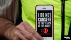 A man holds up his iPhone during a rally in support of data privacy outside the Apple store in San Francisco on Feb. 23, 2016 (AP)