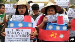 Filipino student activists hold mock Chinese ships to protest recent island-building and alleged militarization by China off the disputed Spratlys group of islands in the South China Sea during a rally near the Malacanang presidential palace in Manila, Ph