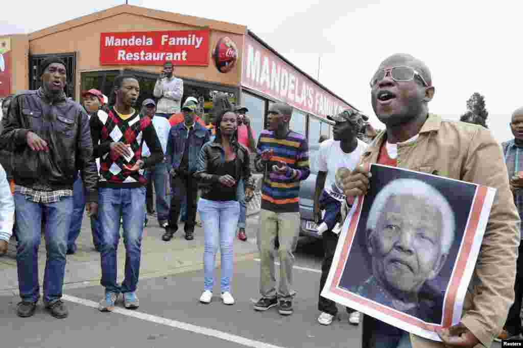 People sing and dance during a gathering of mourners on Vilakazi Street in Soweto, Dec. 6, 2013.