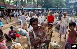 Newly arrived Rohingya Muslims from Myanmar prepare to leave a madrasa that they used as a transit shelter in Shahparirdwip, Bangladesh, Oct. 2, 2017.