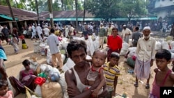 Newly arrived Rohingya Muslims from Myanmar prepare to leave a madrasa that they used as a transit shelter in Shahparirdwip, Bangladesh, Monday, Oct. 2, 2017.