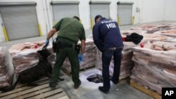 美国海关人员在南加州一个仓库里检查一个毒品走私得递到入口