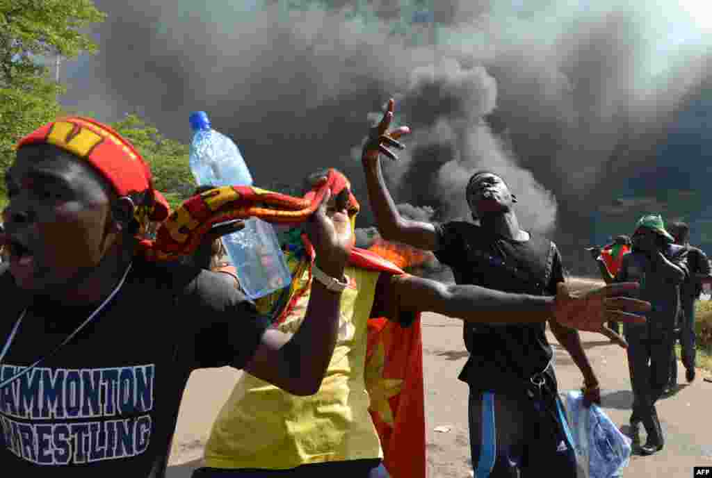 Hundreds of angry demonstrators storm parliament before setting it on fire to protest plans to change the constitution to allow President Blaise Compaore to extend his 27-year rule, Ouagadougou, Burkina Faso, Oct. 30, 2014. 