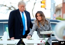 President Donald Trump and first lady Melania Trump put down stones and flowers at a memorial outside for those killed at the Pittsburgh's Tree of Life Synagogue in Pittsburgh, Oct. 30, 2018.