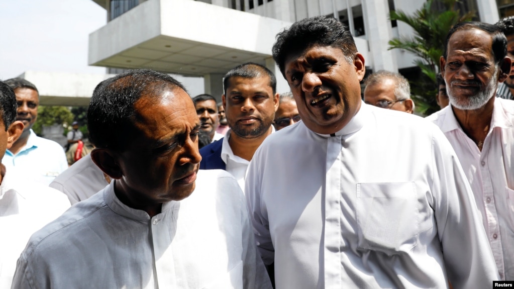 Sajith Premadasa (2nd R) deputy leader and Kabir Hashim (L) senior member of the deposed Prime Minister Ranil Wickremesingehe-led United National Party talk as they leave the Supreme Court after filing a petition against the President Maithripala Sirisena