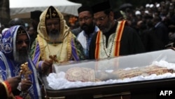 Priests conduct ceremony next to casket bearing remains of Patriarch of the Ethiopian Orthodox Church, Abune Paulos, Aug. 23, 2012.