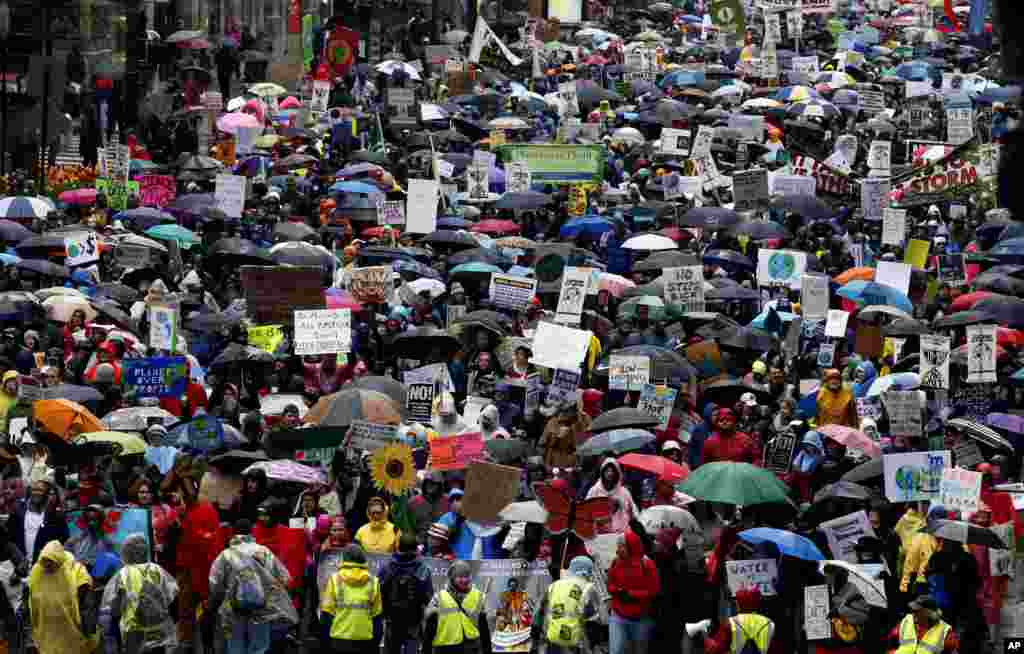 Demonstrators march on the State Street during &quot;100 Days of Failure&quot; protest and march in Chicago, April 29, 2016. Thousands of people across the U.S. are marking President Donald Trump&#39;s hundredth day in office by marching in protest of his environmental policies.
