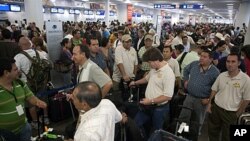 Tourists wait to check their documents at Cancun airport, Mexico, as they prepare to return home, October 26, 2011.
