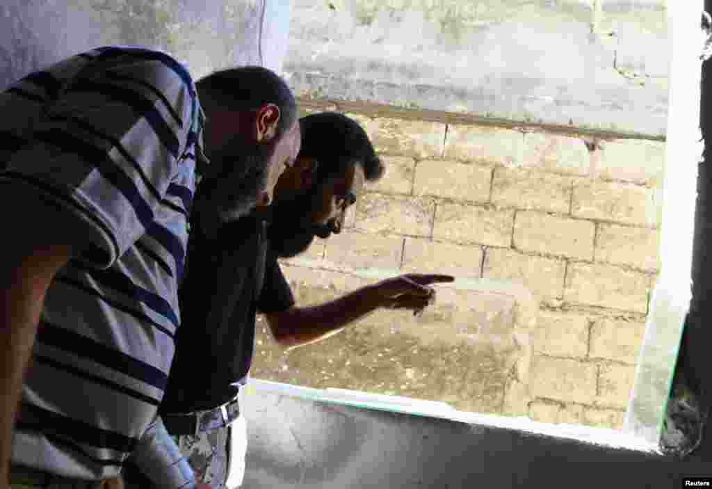 Free Syrian Army fighters use a mirror to locate forces loyal to Syria's President Bashar al-Assad in the old city of Aleppo, Sept. 16, 2013. 