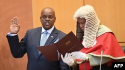 FILE- Botswana's newly elected President Mokgweetsi Masisi (L) takes the oath by the Chief Justice Maruping Dibotelo as the 5th President at the National Assembly in Gaborone on 1 April 2018.