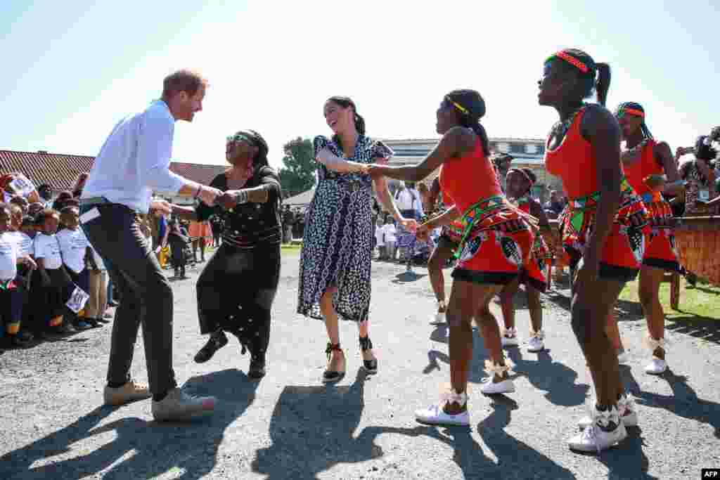 Prince Harry, Duke of Sussex and Meghan, Duchess of Sussex, dance during a visit to the "Justice Desk," an NGO in the township of Nyanga in Cape Town, as they begin their tour of the region.