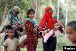 Rohingya women and children walk back from a hospital near the Kutupalong refugee camp, Bangladesh, May 31, 2015.