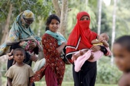 Rohingya women and children walk back from a hospital near the Kutupalong refugee camp, Bangladesh, May 31, 2015.