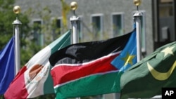 The flag of South Sudan (C) flies after the United Nations General Assembly voted on South Sudan's membership to the United Nations at UN headquarters in New York, July 14, 2011