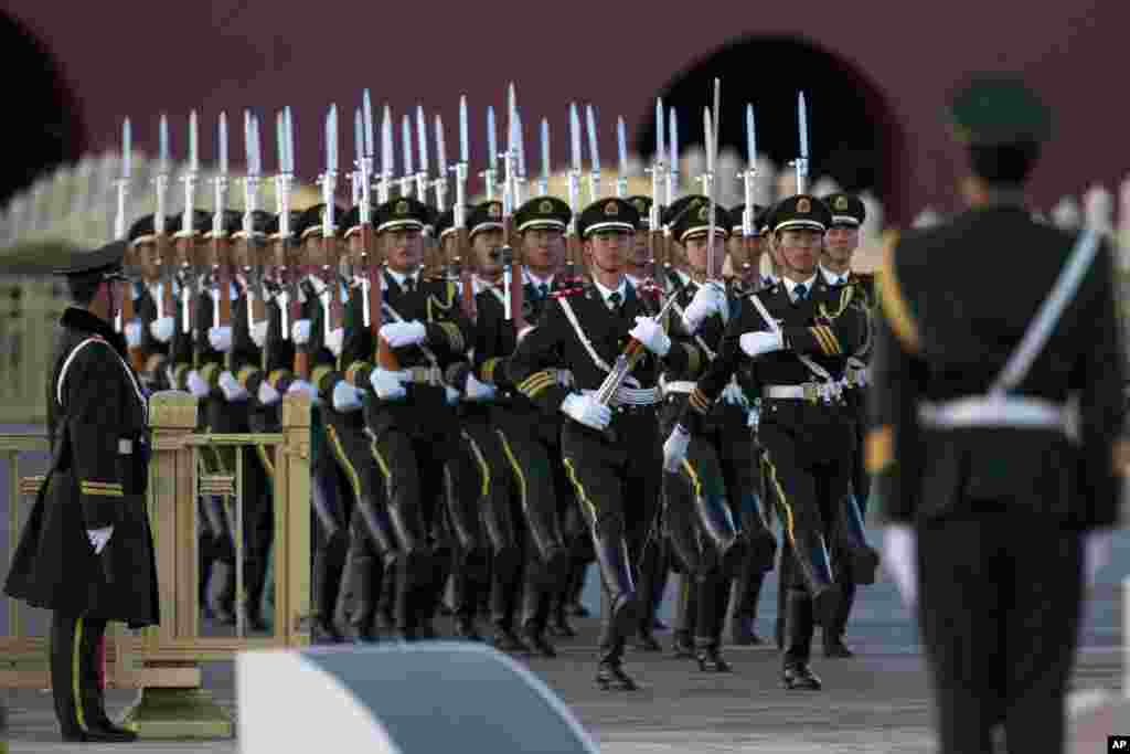Pesawat para militer China berbaris untuk menjalankan upacara penurunan bendera di Lapangan Tiananmen di Beijing.