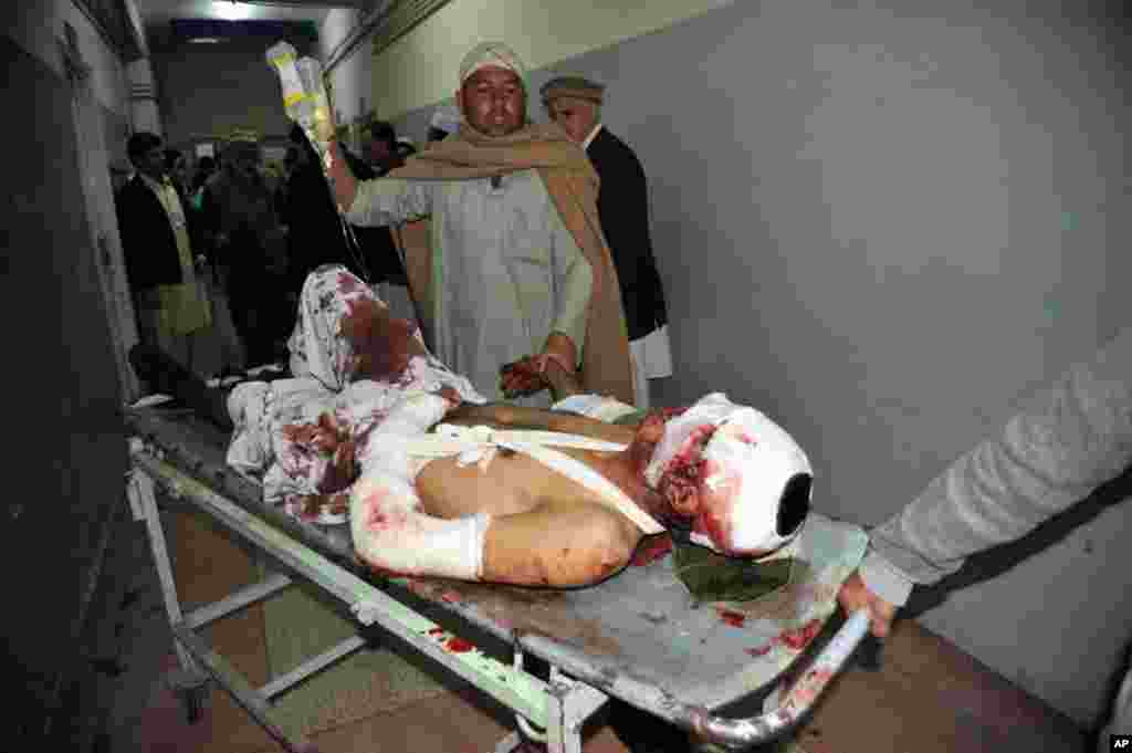 Pakistani men help an injured blast victim at a hospital in Peshawar, following a bomb blast in Jamrud, January 10, 2012. (AFP)