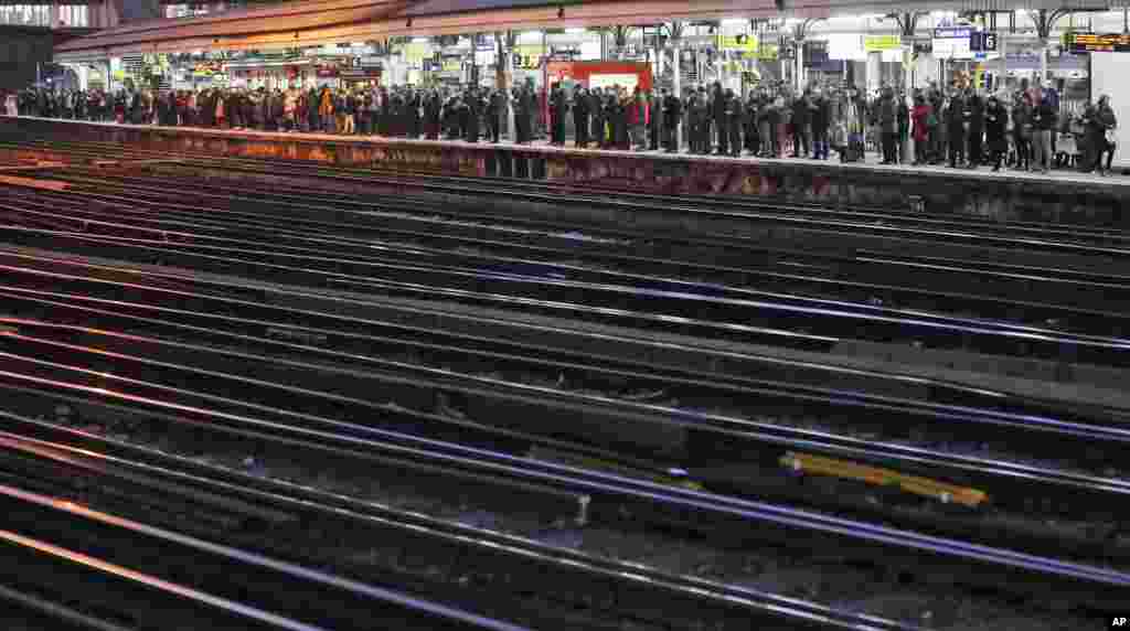 Ratusan penumpang menunggu kereta di stasiun Clapham Junction, London setelah para pekerja kereta api Inggris mulai melakukan mogok kerja.