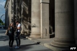 A couple stands in front of the Court of Final Appeal building in Hong Kong, April 10, 2018.