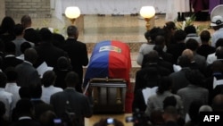 People attend a family ceremony for former Haitian dictator Jean-Claude Duvalier at the chapel of the school Saint-Louis Gonzague in Port-au-Prince, Oct. 11, 2014. 