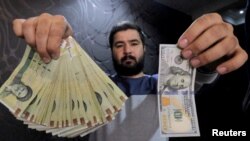 Seorang pegawai money changer menunjukkan uang kertas $100 dan mata uang Rial Iran di sebuah pusat pertokoan di Teheran (foto: ilustrasi). 