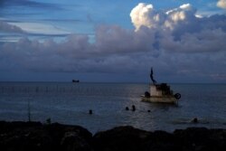 Awan gas putih dari letusan Hunga Ha'apai terlihat dari Garis Pantai Patangata dekat Ibu Kota Tonga Nuku'alof, 21 Desember 2021. (Foto: AFP/Mary Lyn Fonua)