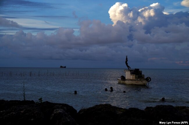 Awan gas putih dari letusan Hunga Ha'apai terlihat dari Garis Pantai Patangata dekat Ibu Kota Tonga Nuku'alof, 21 Desember 2021. (Foto: AFP/Mary Lyn Fonua)
