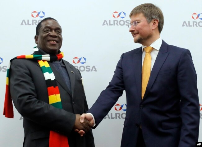 Zimbabwe's President Emmerson Dambudzo Mnangagwa, left, and CEO of of the Alrosa diamond mining company Sergey Ivanov shake hands during their meeting in Moscow, Jan. 14, 2019.