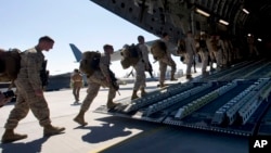 FILE - U.S. Marines are seen boarding a military transport plane.