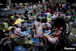 Migrants, part of a caravan of thousands of migrants from Central America en route to the United States, rest along the sidewalks of Tapachula city center, Mexico, Oct. 21, 2018.