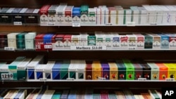 FILE - Cigarette packs are displayed at a smoke shop in New York.