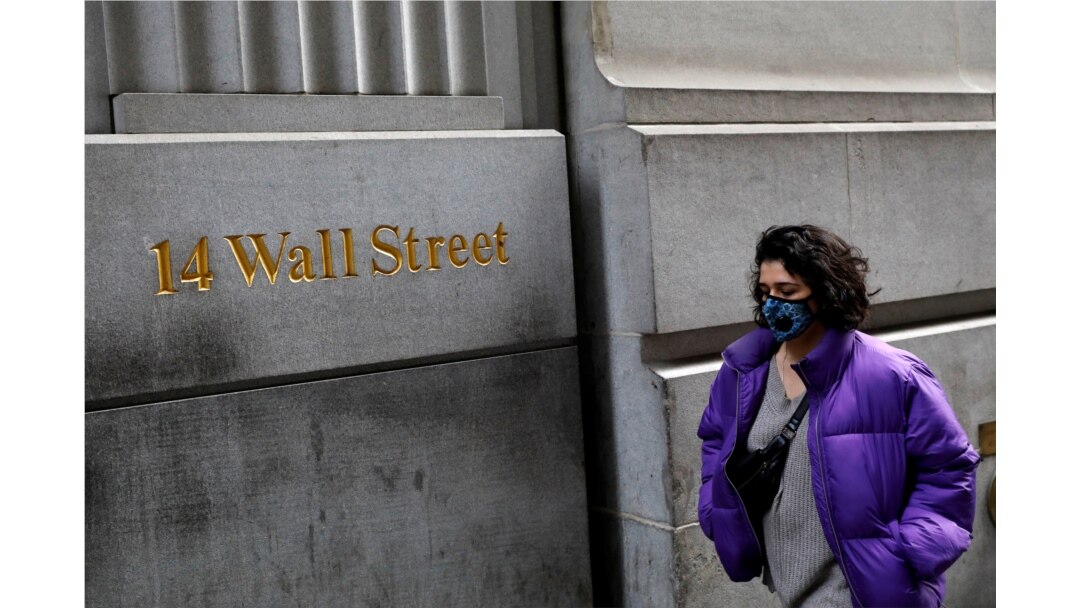 A person wearing a face mask walks along Wall Street after further cases of coronavirus were confirmed in New York City, New York, U.S., March 6, 2020.