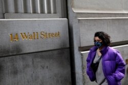 A person wearing a face mask walks along Wall Street after further cases of coronavirus were confirmed in New York City, New York, U.S., March 6, 2020.