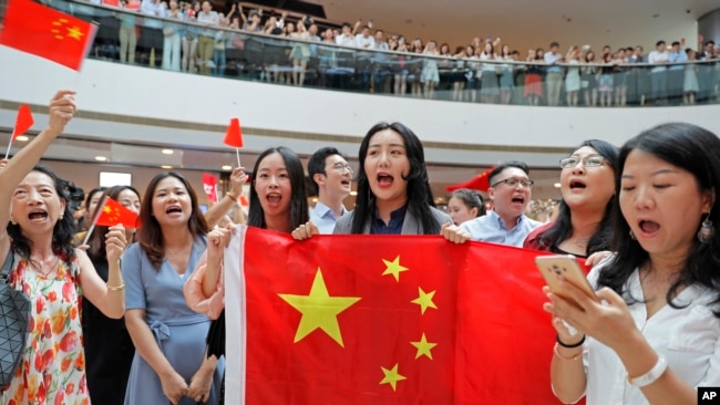 亲北京的支持者手举中国国旗在香港金融中心商场唱中国国歌。（2019年9月12日）