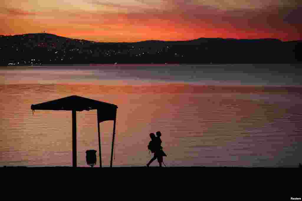 A man walks on the shore of the Sea of Galilee during sunset near the northern city of Tiberias October 29
