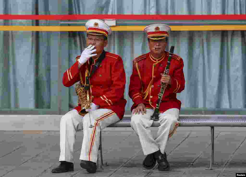 Anggota band merokok di bangku di sela-sela waktu istirahat di Kunming, provinsi Yunnan, China. China akan menaikkan pajak rokok menjadi 11 persen dari 5 persen, kata Menteri Keuangan awal bulan Mei, sebuah langkah yang diambil untuk mengurangi jumlah perokok di negara produsen dan konsumen terbesar rokok di dunia itu.