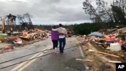 Люди йдуть серед руїн, спричинених торнадо в графстві Лі штату Алабама, 3 березня 2019 року