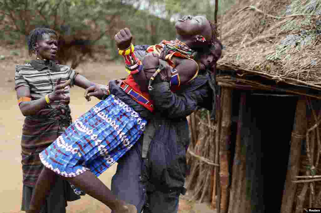 Seorang pria memegangi seorang anak perempuan suku Pokot di dekat kota Marigat, Kenya yang berusaha lari setelah tahu dia akan dikawinkan.