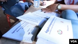 Cambodian health workers give away information on HIV prevention to residents in Peam village, Kandal province, Cambodia, Monday, February 22, 2016. (Photo: Aun Chhengpor/VOA Khmer)