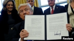 U.S. President Donald Trump holds an executive order dealing with the structure of the National Security Council after signing it in the Oval Office at the White House in Washington, Jan. 28, 2017. 