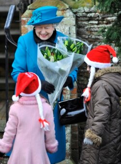 Ratu Elizabeth menerima bunga di luar gereja St. Mary setelah menghadiri kebaktian Natal tahunan di Royal Estate di Sandringham di Norfolk, Inggris timur, 25 Desember 2012. (Foto: REUTERS/Toby Melville)