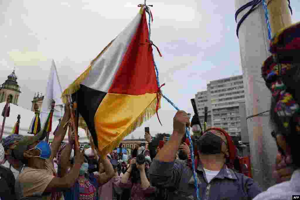 Un indígena maya iza la bandera de los Pueblos Indígenas de Guatemala durante una protesta contra el Bicentenario de la Independencia de Guatemala.