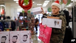Joey Ellis adds to his armful of items while shopping for deals at a J.C. Penney store, Nov. 24, 2017, in Seattle. Black Friday has morphed from a single day into a whole season of deals, so shoppers may feel less need to be out. 