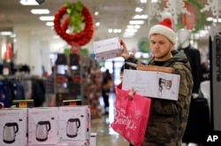 Joey Ellis adds to his armful of items while shopping for deals at a J.C. Penney store, Nov. 24, 2017, in Seattle. Black Friday has morphed from a single day into a whole season of deals, so shoppers may feel less need to be out.