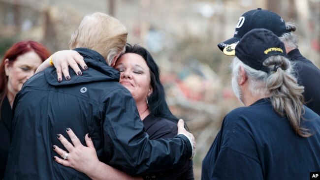 El rpesidente Donald Trump reconforta a la gente entre la devastación y los escombros en Beauregard, Ala., el viernes 8 de marzo de 2019, durante un recorrido por áreas donde los tornados mataron a 23 personas en el Condado de Lee, Ala.